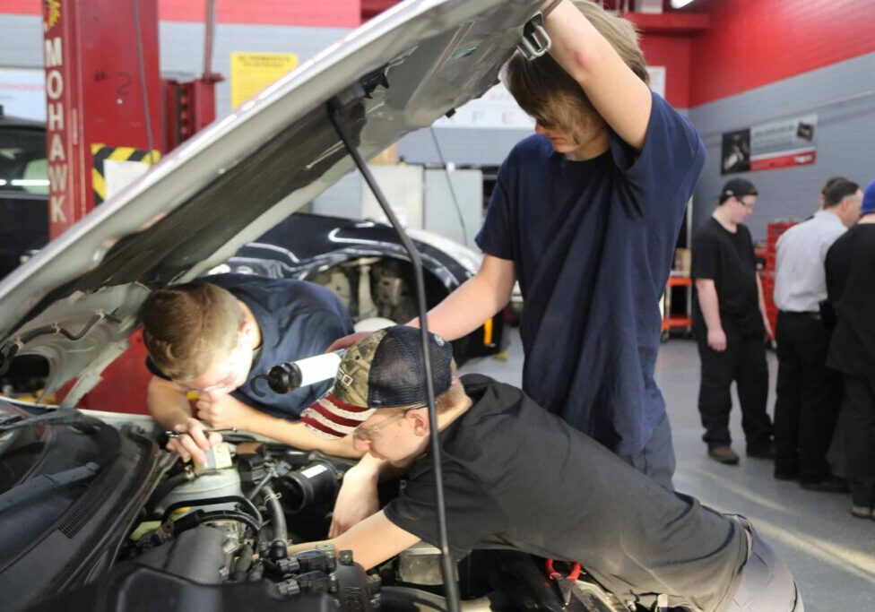 students working on car engine