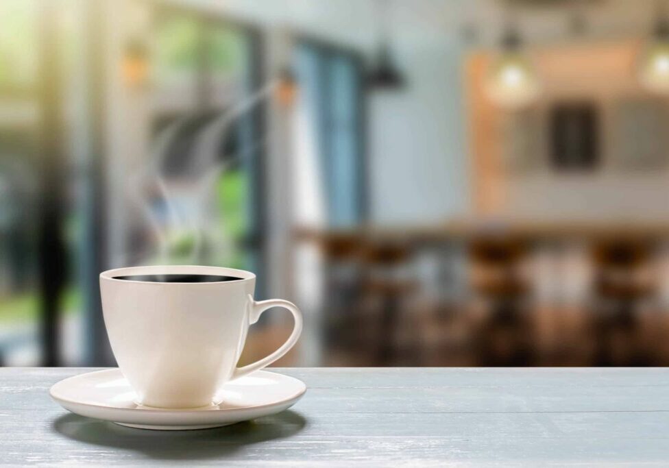 Hot cup of coffee on wooden desk