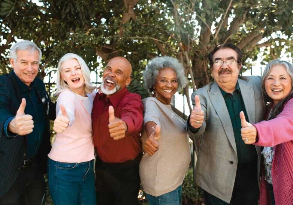 Cheerful retired senior friends showing thumbs up
