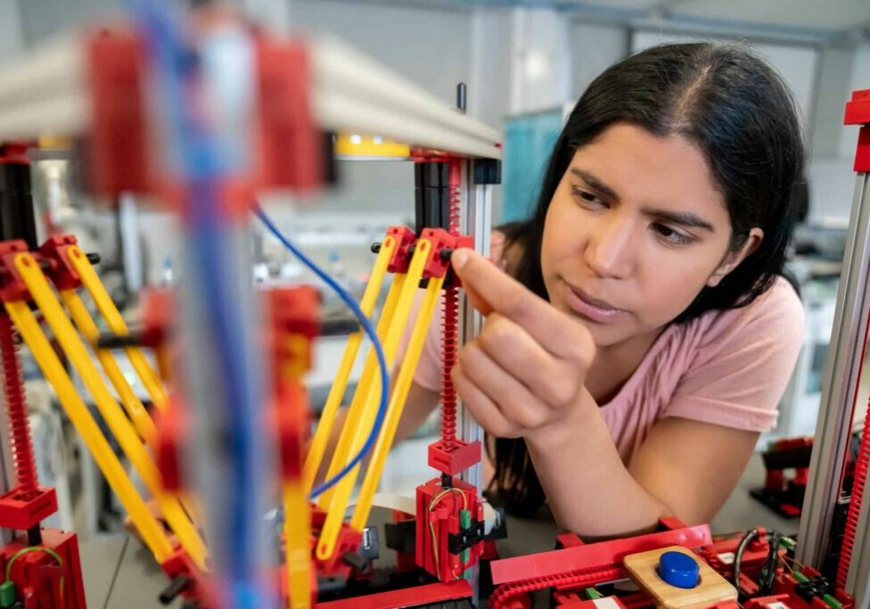 Female engineer at the lab building a robot