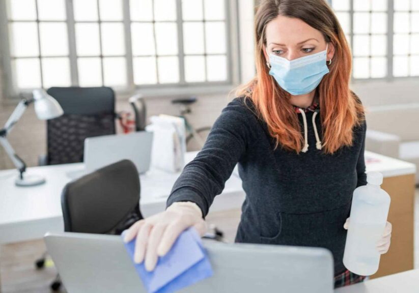 Woman in the office using disinfectant