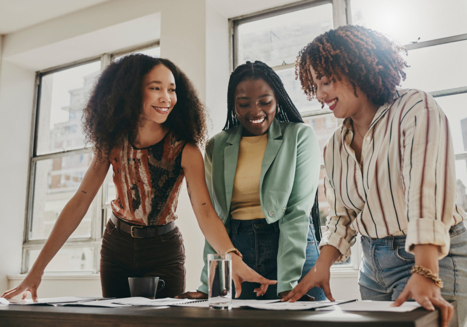 Teamwork, collaboration and planning black women with documents, paperwork or design strategy in office. Business startup, gender equality and marketing ideas of diversity people in workspace meeting