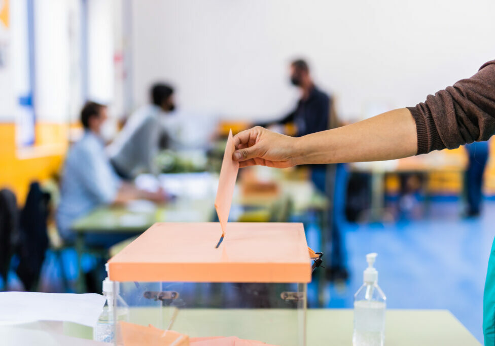 Autonomous community of Madrid elections. Democraty referendum for government vote. Hand posing an envelop in a ballot box for community elections