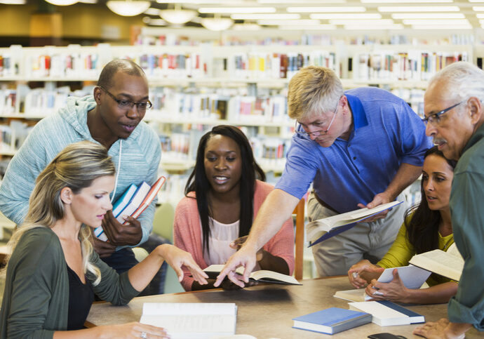 Adult students studying  together in library
