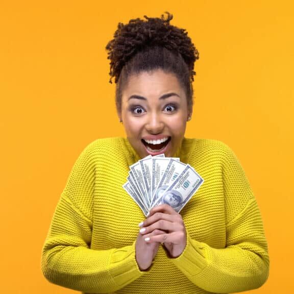 Excited Afro-American woman holding bunch of dollars, lottery winner, fortune
