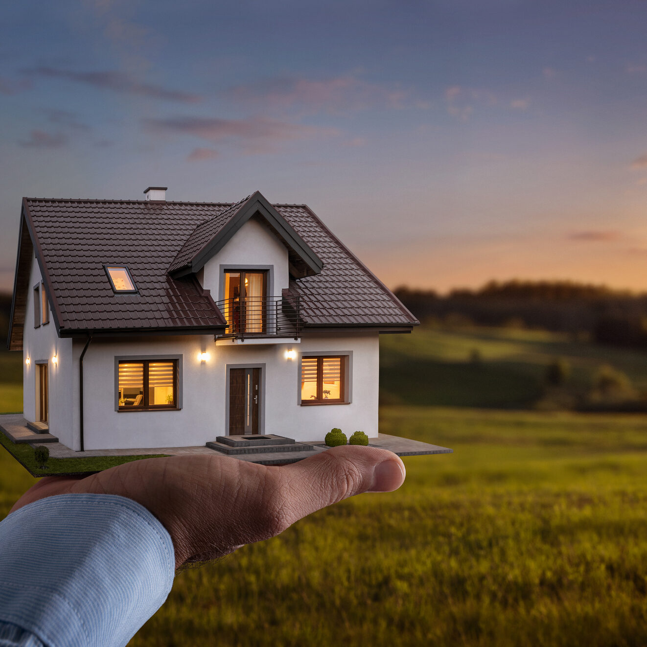 Concept of buying or building a new home. Male hand showing, offering a new dream house at the empty field with copy space