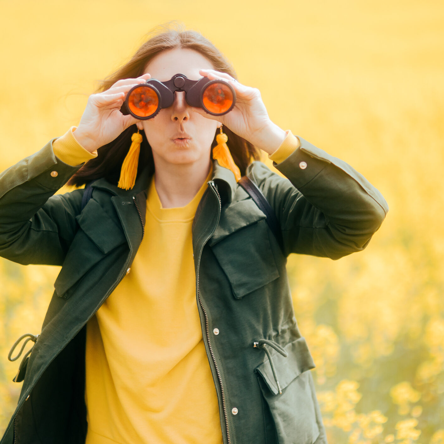 Funny Travel girl watching and exploring outdoors standing in floral field