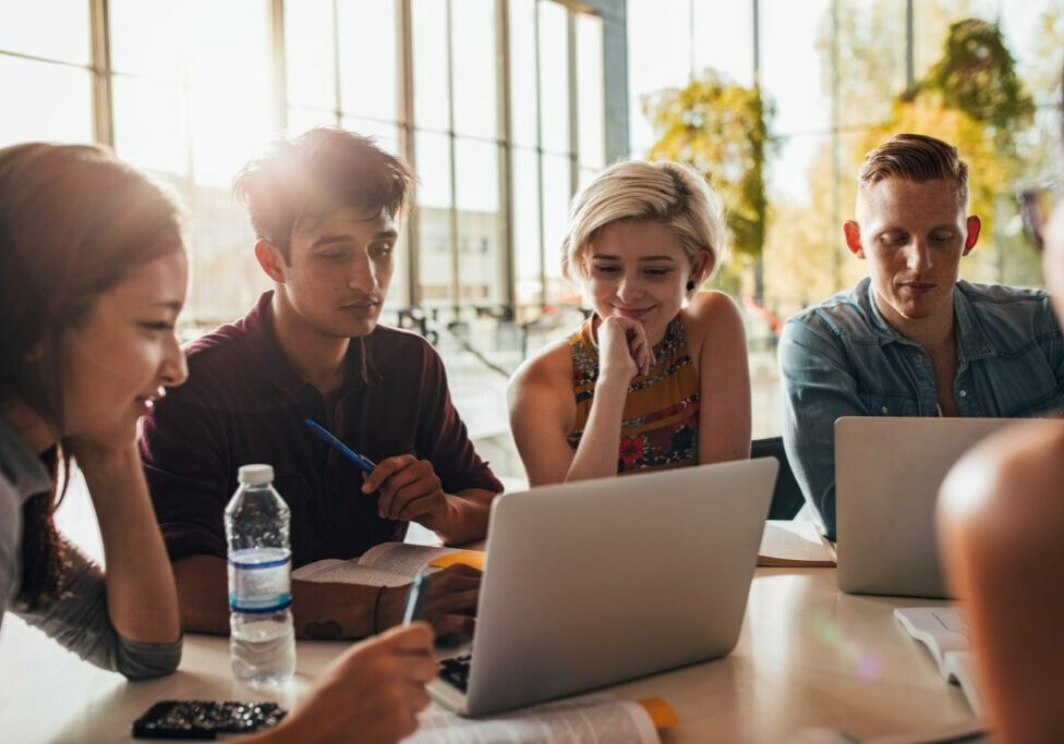 Group of students sitting at table in library