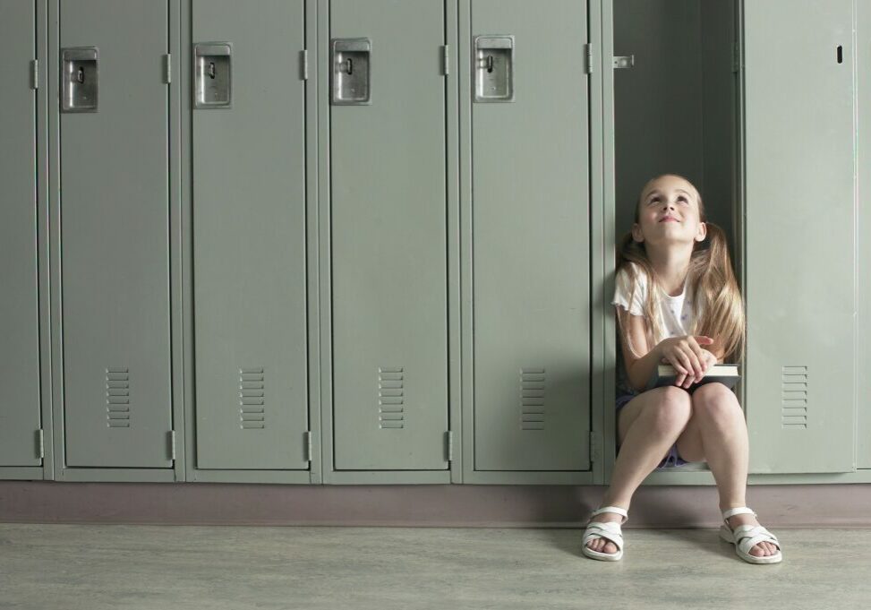 Girl sitting in locker reading