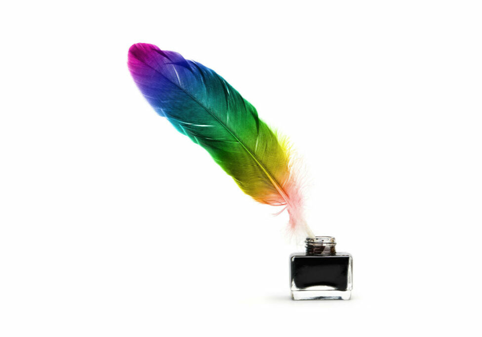 rainbow colored feather in an ink well