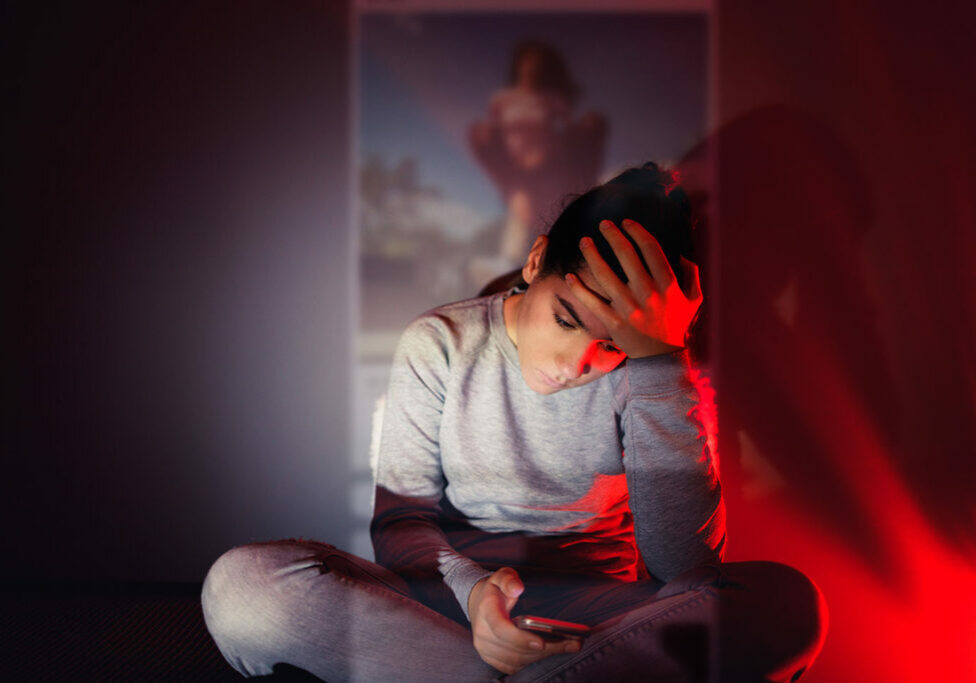 girl using her smartphone in the dark room